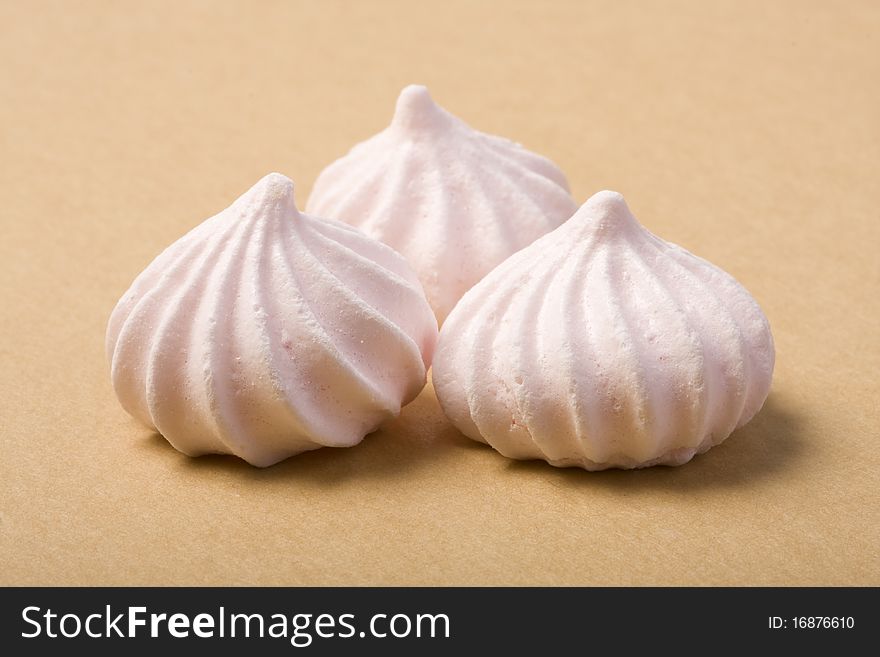 Three Pink Merinque cakes on the cardboard background. Shallow depth of field.
