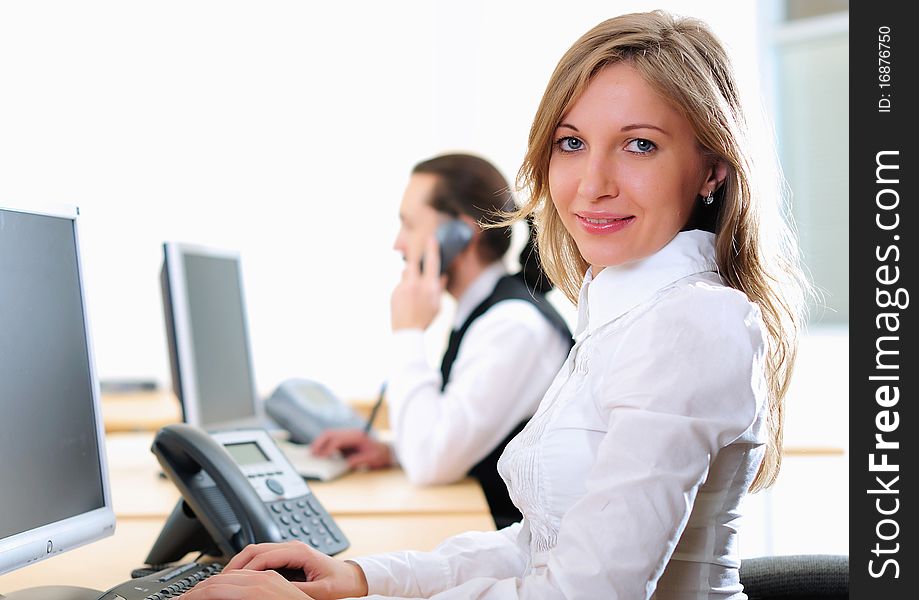 A young girl in his office at his workplace works at the computer