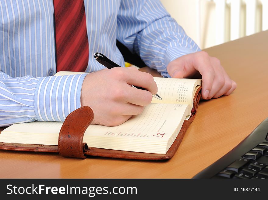 A young business man working in an office at his workplace.