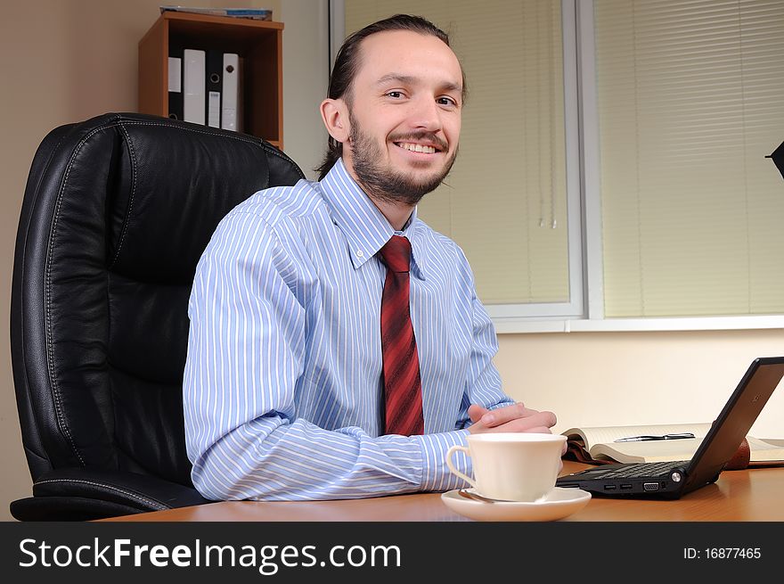 A young business man working in an office at his workplace.