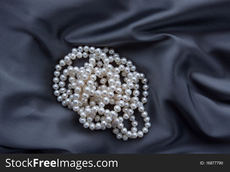 Beatiful white pearls necklace on blue satin