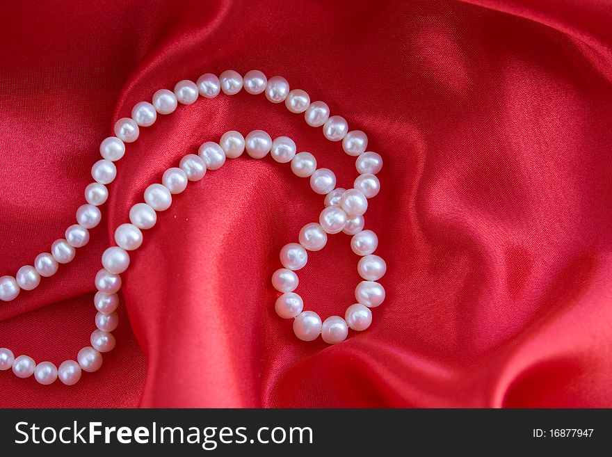 Luxury white Pearl's necklace on red background
