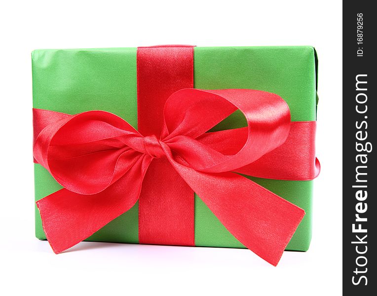 Gift in green wrapping with a red bow on white background