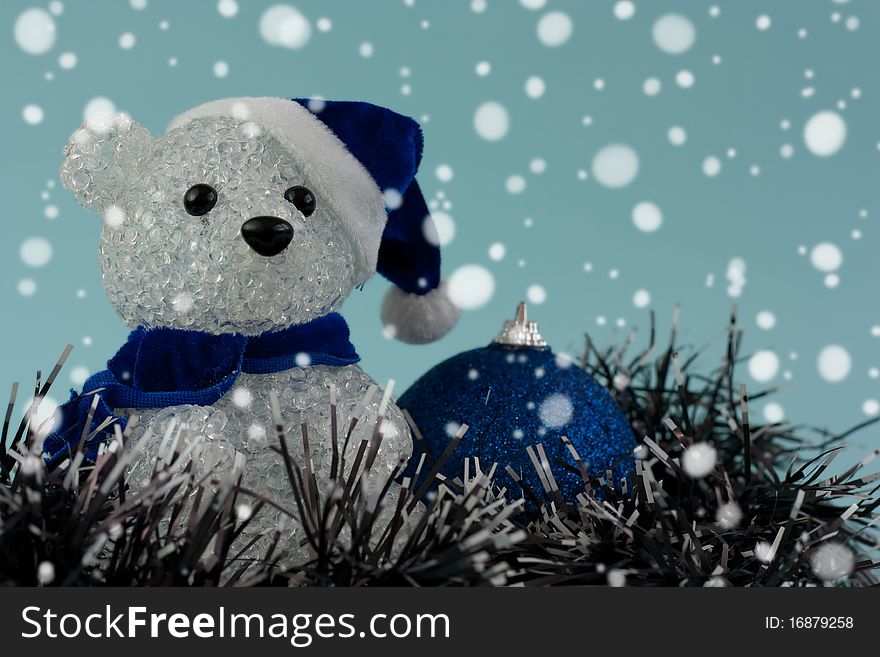 Christmas teddy bear and bauble under the snow