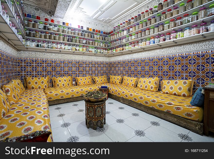 Moroccan interior with variety of spices on shelves and herbal tea in the middle of the room