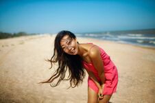 Young Asian Woman Standing At Beach. Beautiful Young Woman In A Pink Dress Walking Back From The Beach. Stock Images