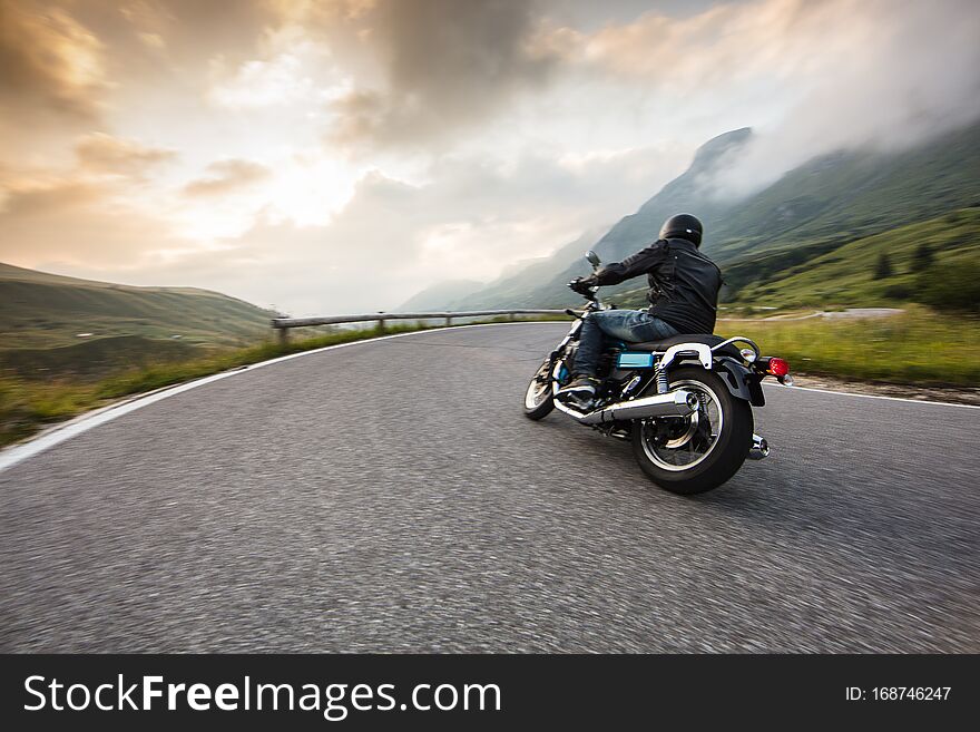 Motorcycle driver riding in Dolomite pass, Italy, south Europe.