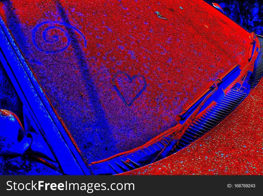 Heart shape and spiral carving appearance on rusted dirty unknown car. The pop art or little graffiti inscription on abandoned car