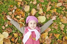 Little Girl At Grass And Leafs In The Park. Stock Photo Little Girl At Grass And Leafs In The Park. Stock Photo