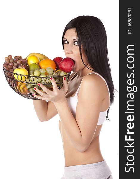 A woman is wearing a sports bra and holding up some fruit. A woman is wearing a sports bra and holding up some fruit.