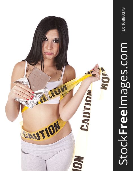 A woman is looking unhappy with chocolate and caution tape around her. A woman is looking unhappy with chocolate and caution tape around her.