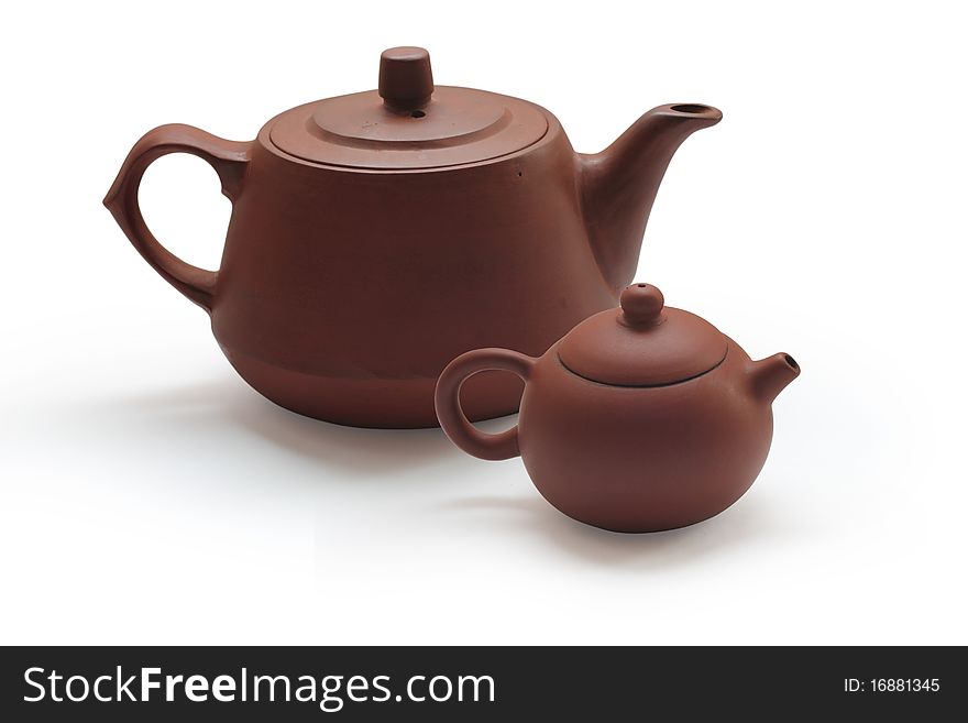 Clay teapots and tea strainer at row on white background