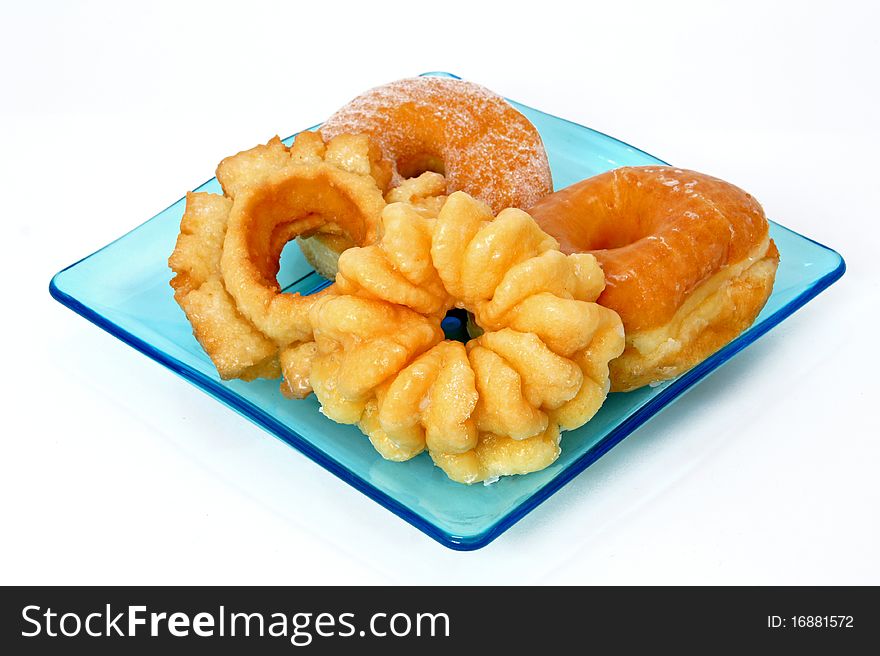 Donuts and breakfast pastries on a blue plate. Donuts and breakfast pastries on a blue plate