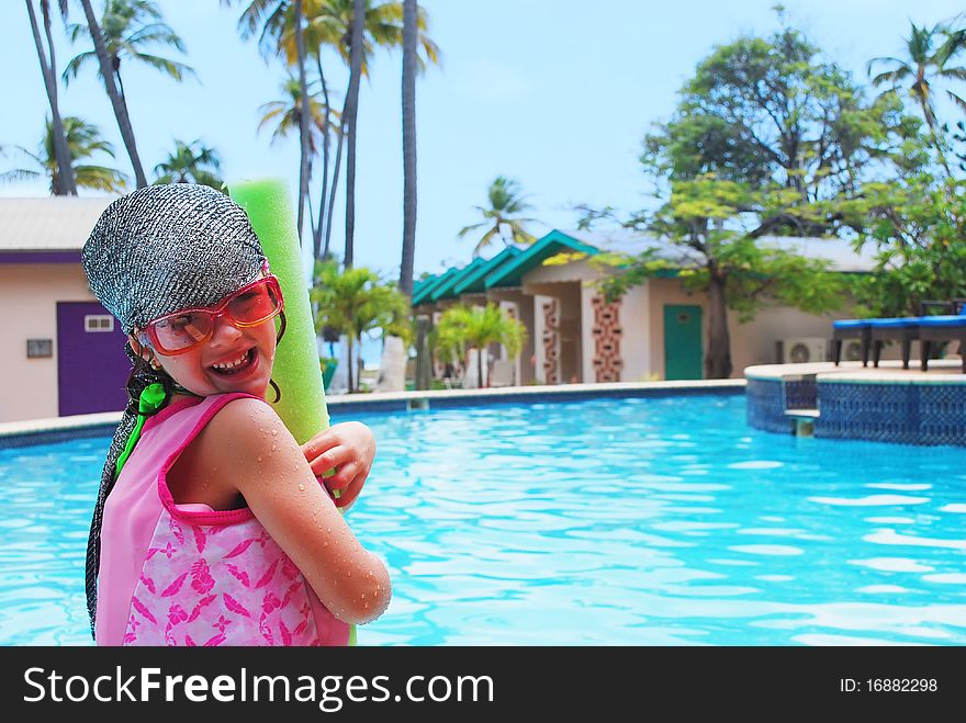 Happy little girl ready to swim with pool noodle in tropical resort. Happy little girl ready to swim with pool noodle in tropical resort.
