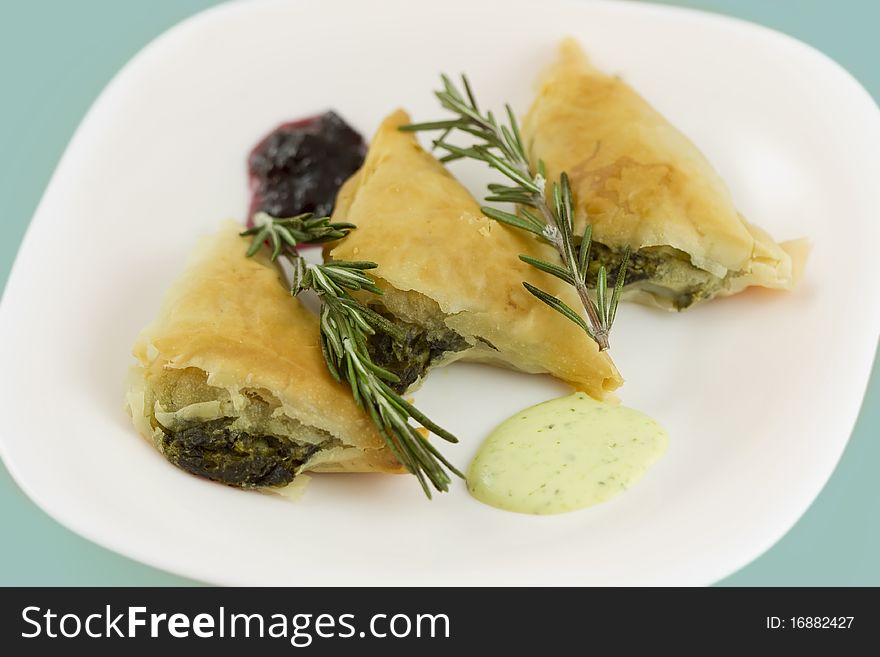 Greek spinach filled pastries with rosemary leafs. 100mm macro lens and studio lights. Greek spinach filled pastries with rosemary leafs. 100mm macro lens and studio lights.