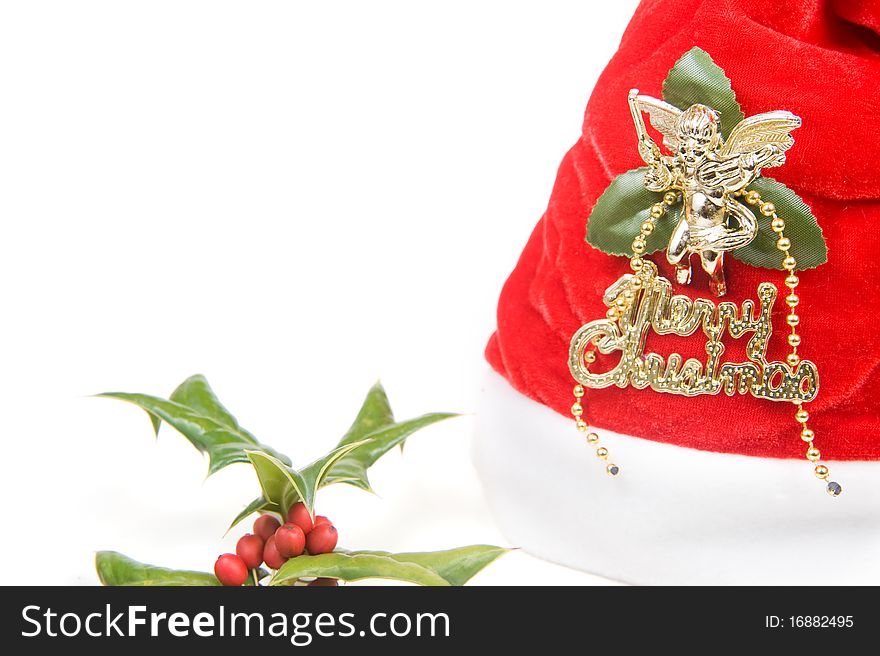 Red santa claus hat and holly berry isolated on white background