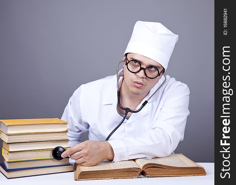 Young male doctor studying medical books. Studio shot.