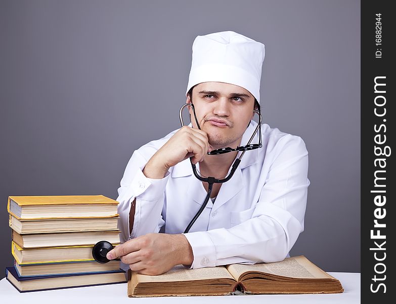 Young male doctor studying medical books. Studio shot.