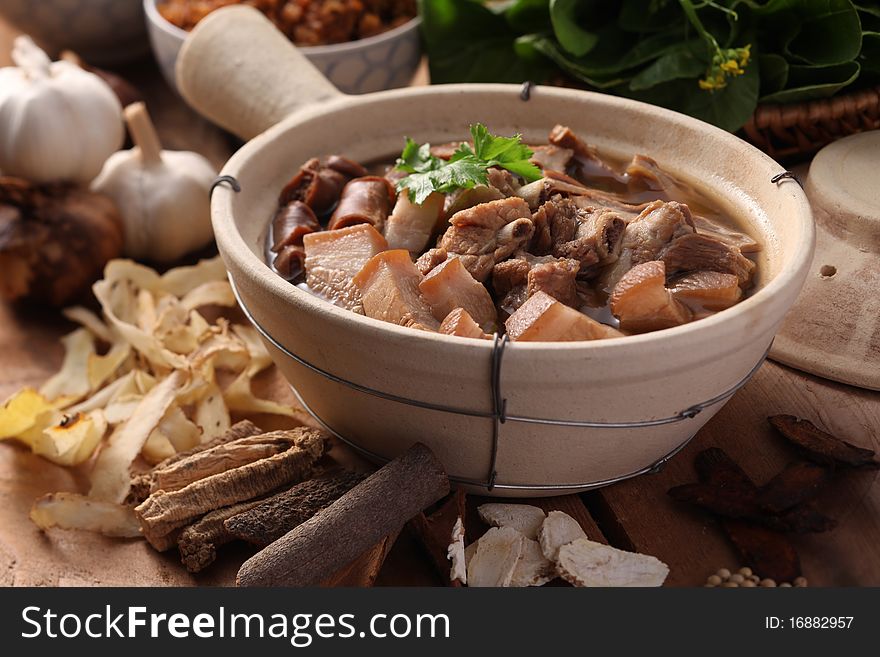 A Malaysian herbal pork dish with herbs as background. A Malaysian herbal pork dish with herbs as background