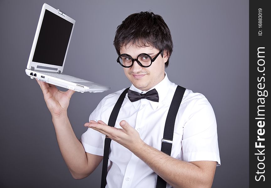 Portrait of funny fashion men in suspender with bow tie and glasses keeping notebook. Studio shot. Portrait of funny fashion men in suspender with bow tie and glasses keeping notebook. Studio shot.