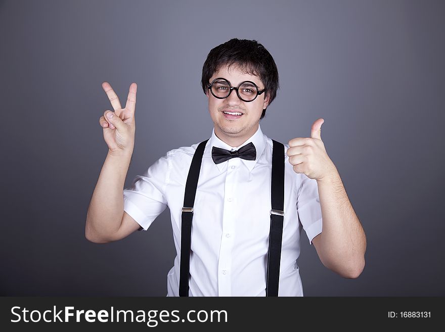 Portrait of funny fashion men in suspender with bow tie and glasses show OK symbols. Studio shot.