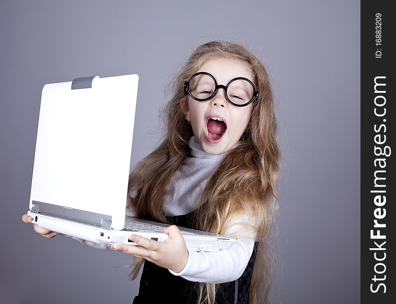 Young little girl in glasses with notebook. Studio shot.