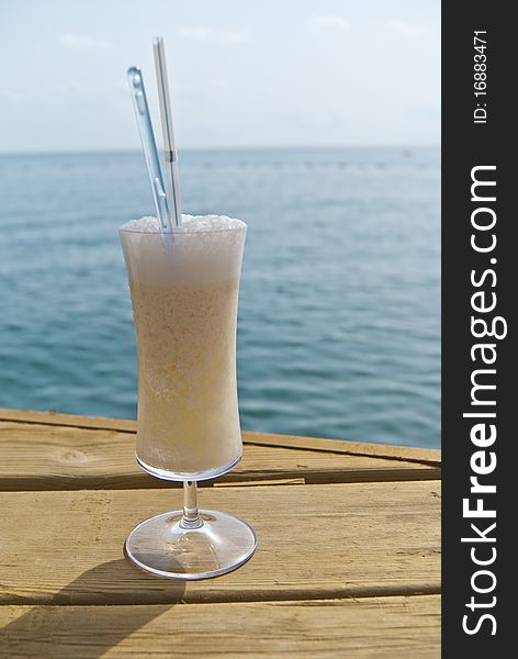 Milk cocktail with rum, cream of coconut and pineapple juice near the sea. Milk cocktail with rum, cream of coconut and pineapple juice near the sea