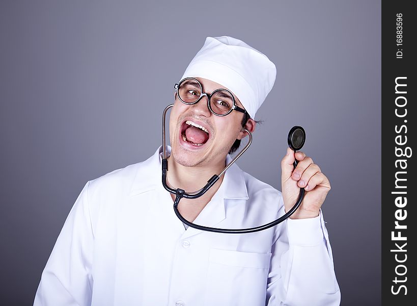 Crazy doctor with a stethoscope. Studio shot.