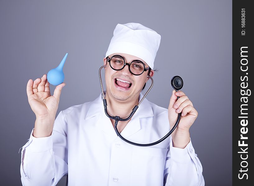 Crazy doctor with a stethoscope and enema. Studio shot.