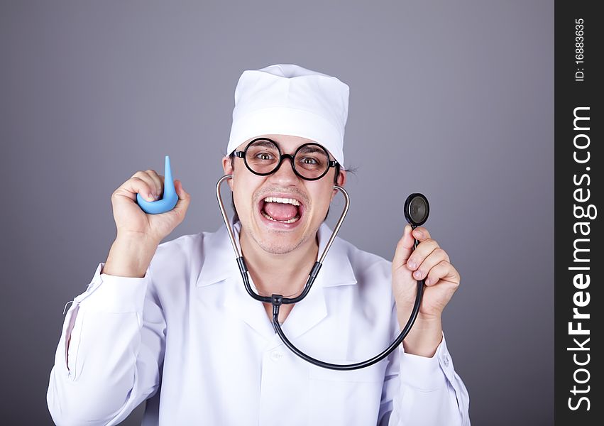 Crazy doctor with a stethoscope and enema. Studio shot.