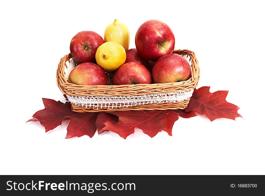 Wooden basket full of autumn apples and lemons isolated on a white background. Wooden basket full of autumn apples and lemons isolated on a white background.