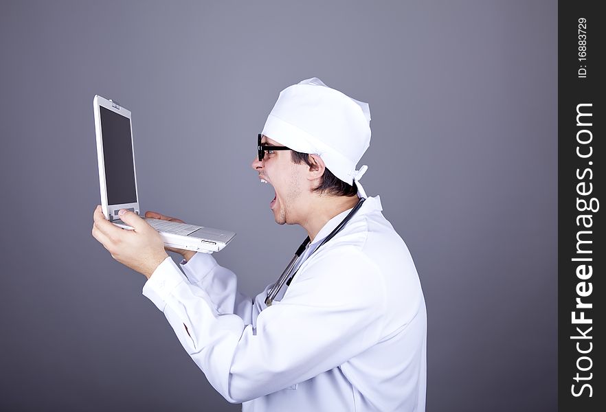 Shouting doctor with notebook. Studio shot.