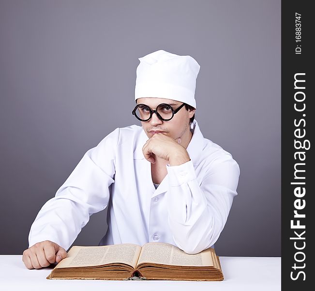 Young male doctor studying medical book. Studio shot.