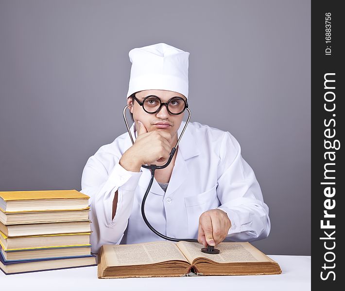 Young male doctor studying medical books. Studio shot.