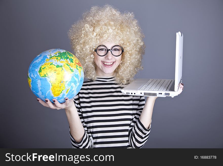 Funny girl in glasses keeping notebook and globe. Studio shot.