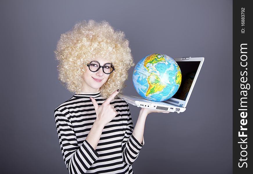 Funny girl in glasses keeping notebook and globe. Studio shot.