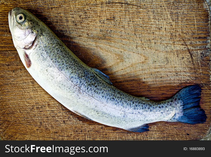 Preparing rainbow trout on wooden plate. Preparing rainbow trout on wooden plate