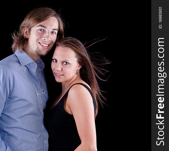 Young cute couple with long hair over black background. Young cute couple with long hair over black background.