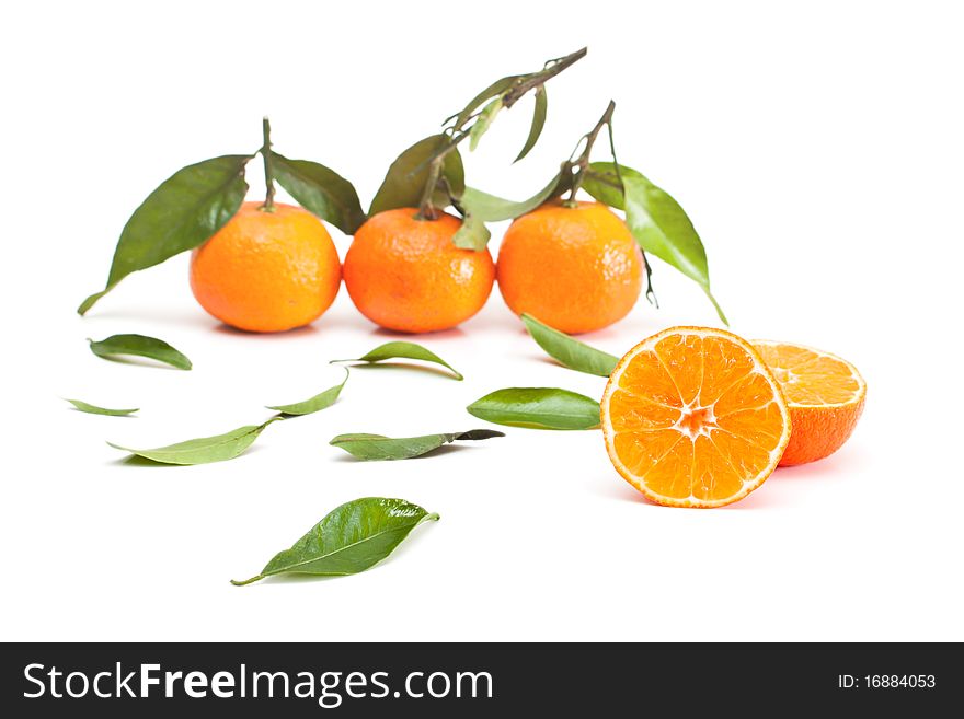 Tangerines with green leaves isolated on white.