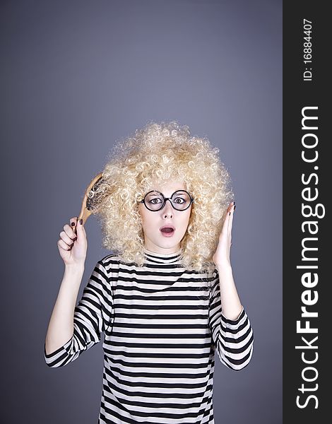 Surprised girl with comb. Studio shot.