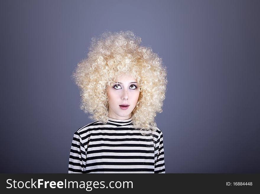 Portrait of funny girl in blonde wig. Studio shot.