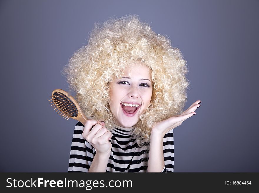 Surprised girl with comb. Studio shot.