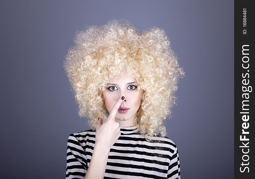 Portrait of funny girl in blonde wig. Studio shot.