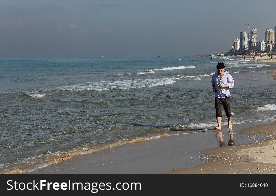 Young smiling businessman celebrating on the beach. Young smiling businessman celebrating on the beach