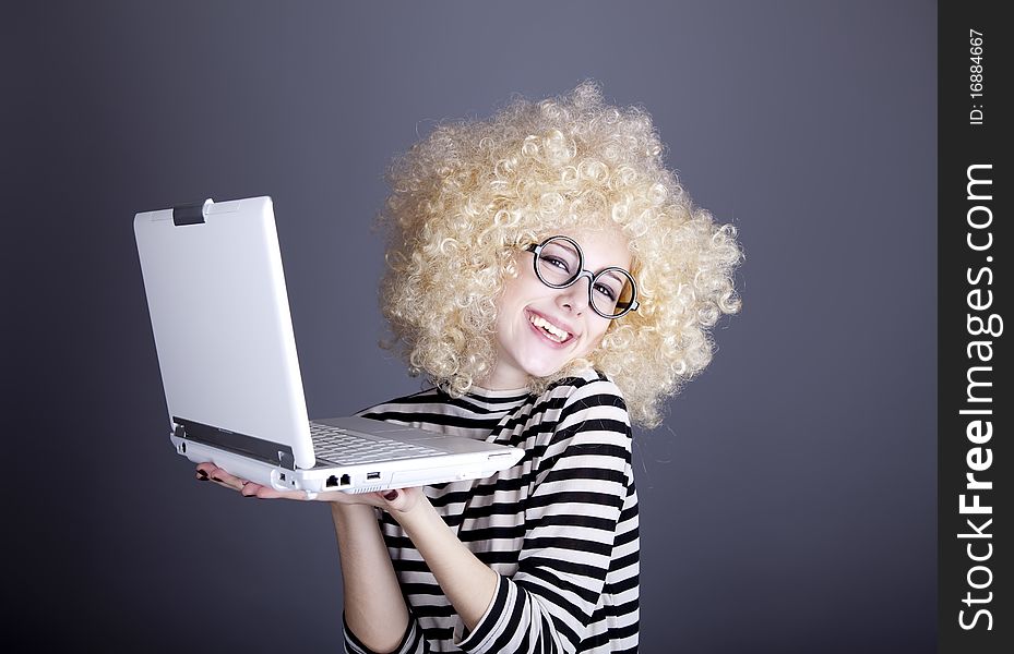 Portrait of funny girl in blonde wig with laptop.