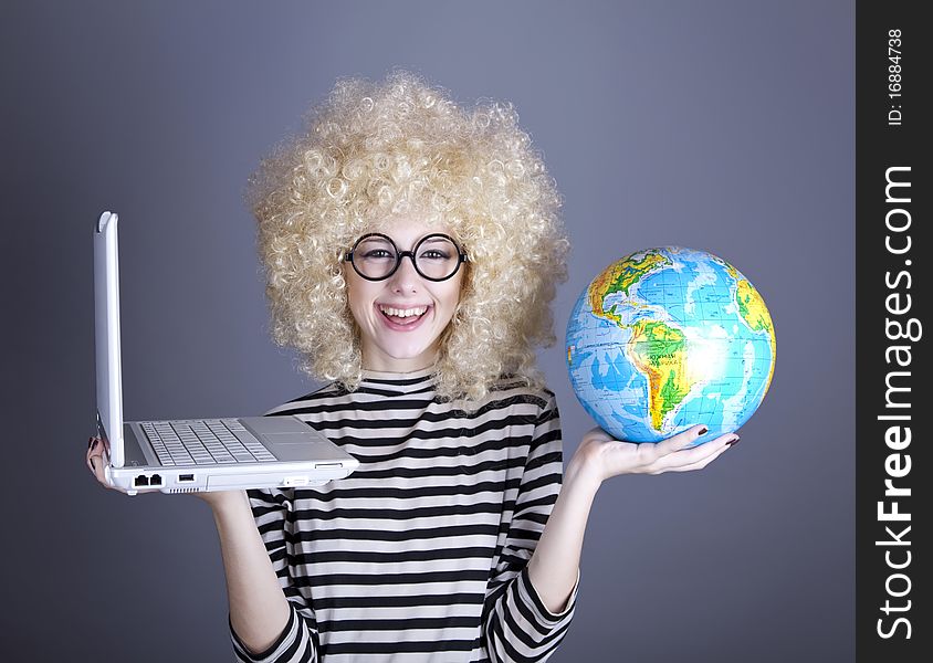 Funny girl in glasses keeping notebook and globe. Studio shot.