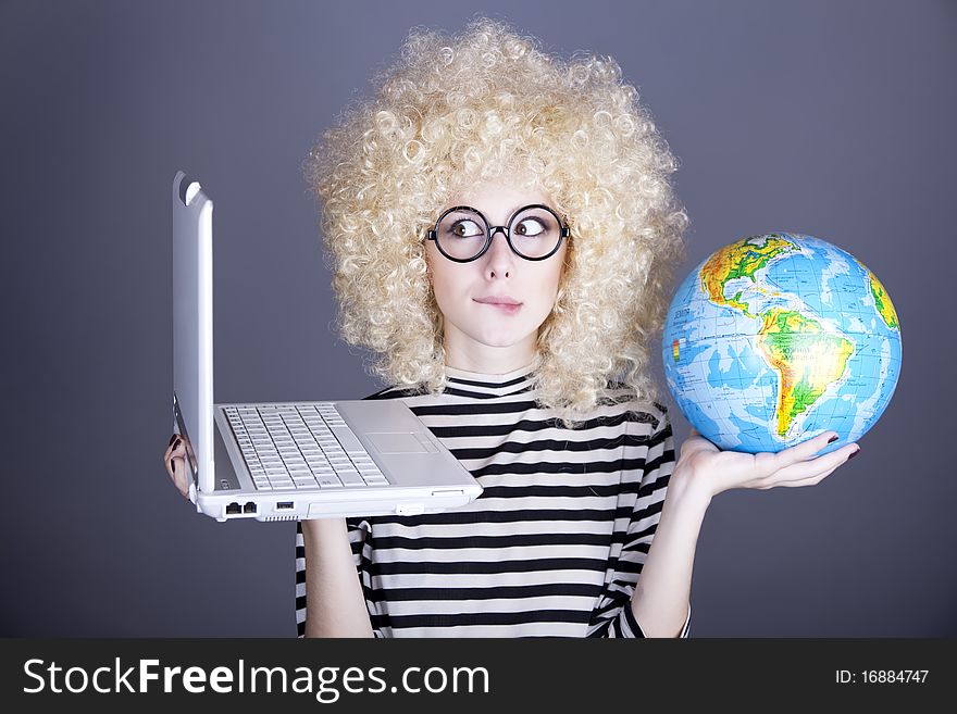 Funny girl in glasses keeping notebook and globe. Studio shot.