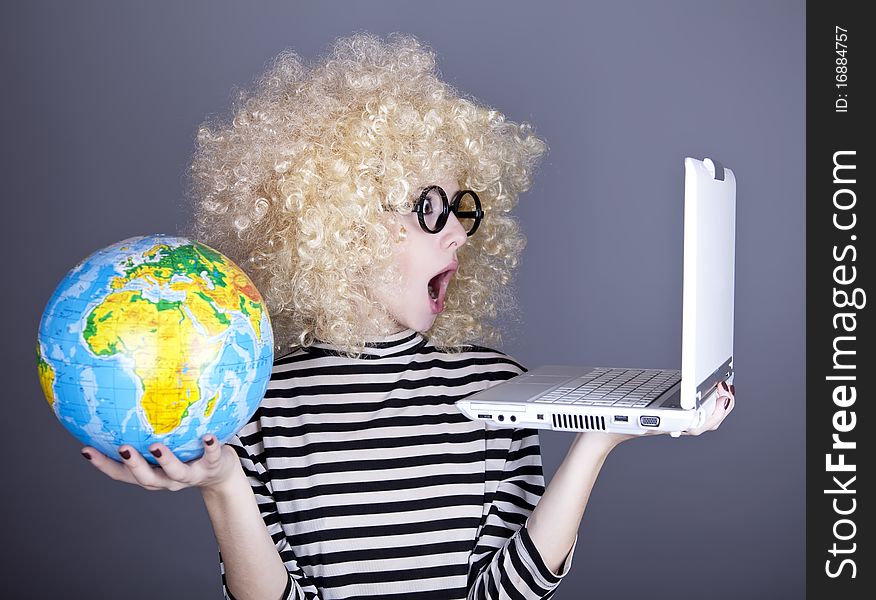 Funny girl in glasses keeping notebook and globe. Studio shot.