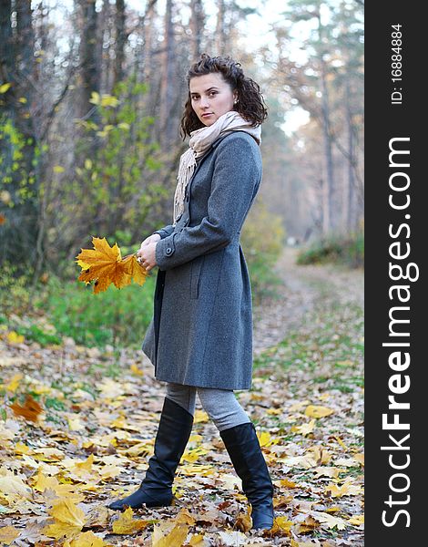 Pretty young girl in autumn fores  in coat