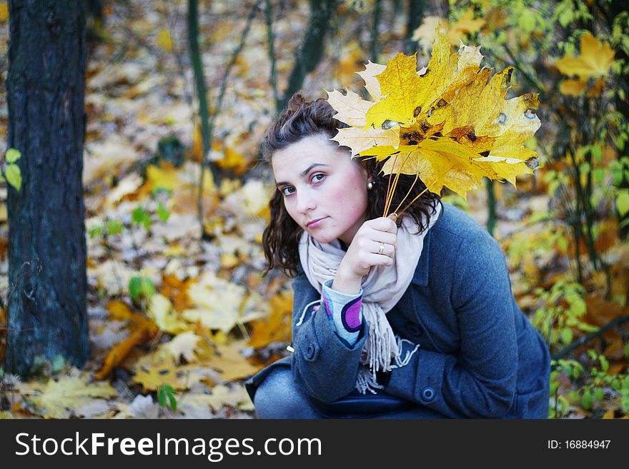 Pretty young girl in autumn fores  in coat